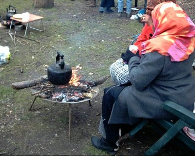 Women in hijab sitting round fire