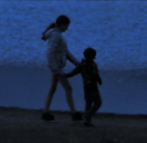 Children by the water in the dusk