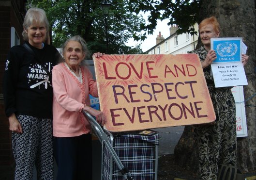 Mabel Cluer holding 'Love and Respect Everyone' poster