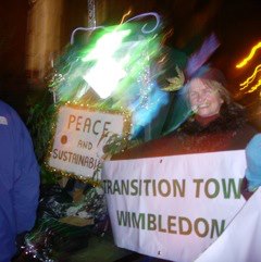 Joyce Pountain holds up banner beside Maisie in rickshaw